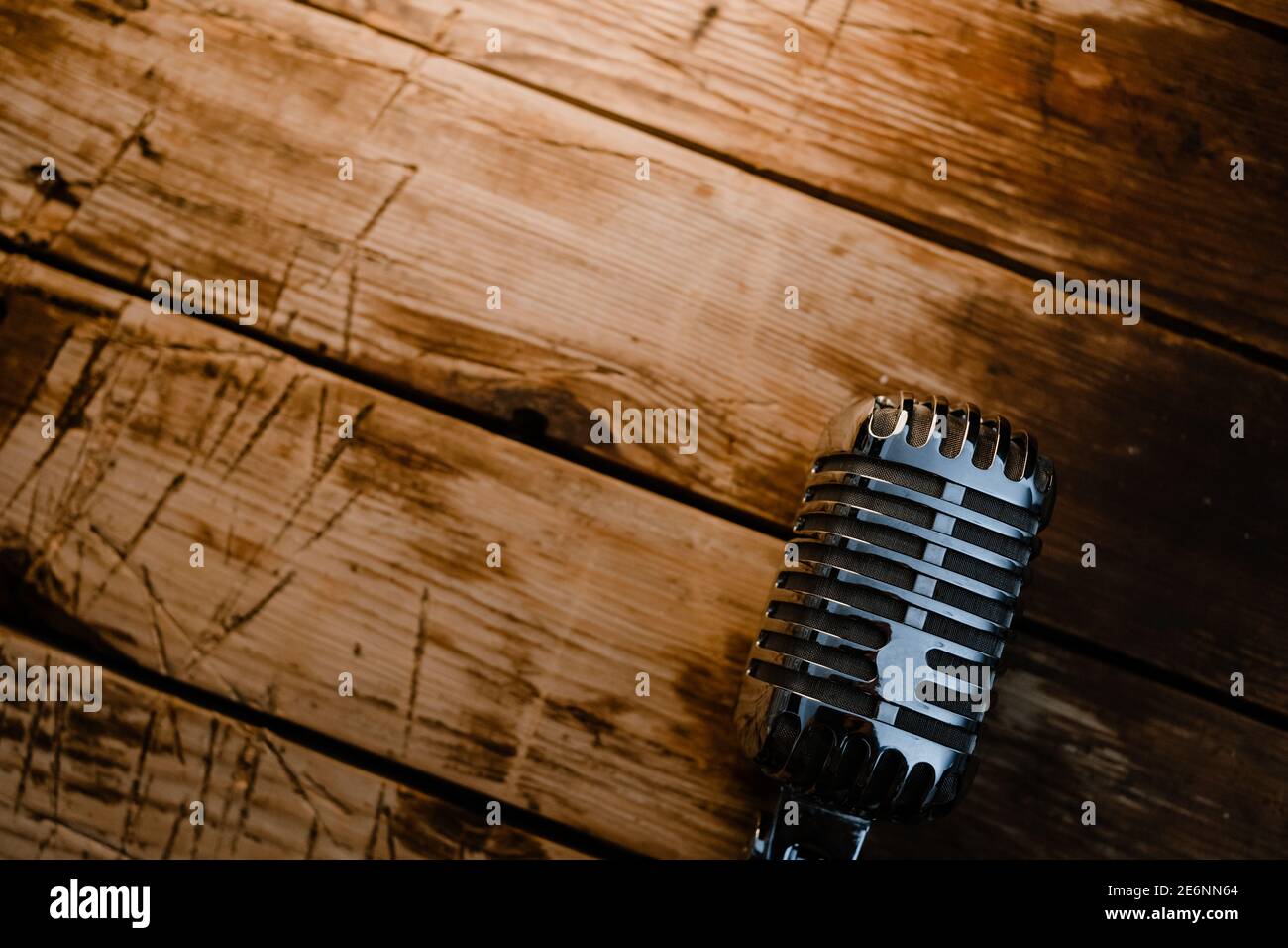 Micrófono de estilo retro genérico sobre fondo de madera caliente con copia espacio para texto Foto de stock