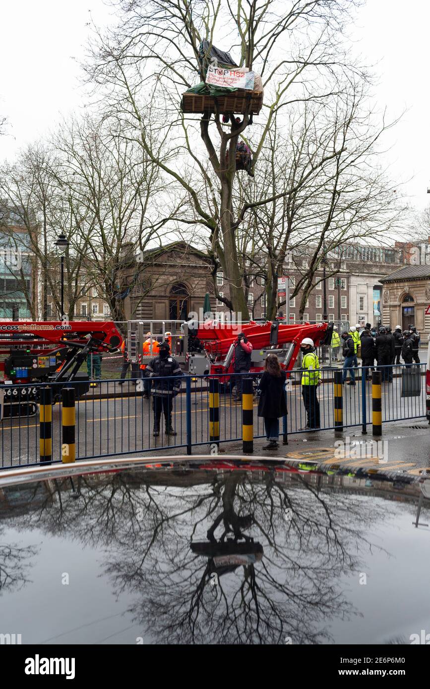 Desalojo de manifestantes de Stop HS2 del campamento en Euston Square Gardens, Londres, 27 de enero de 2021. Los recolectores de cerezas se descargan junto a un árbol. Foto de stock