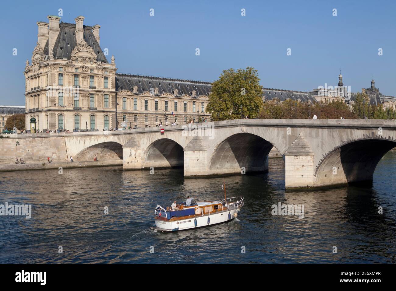 Barco en el Sena en el fondo el Musee de Louvre y el puente Pont Royal Foto de stock