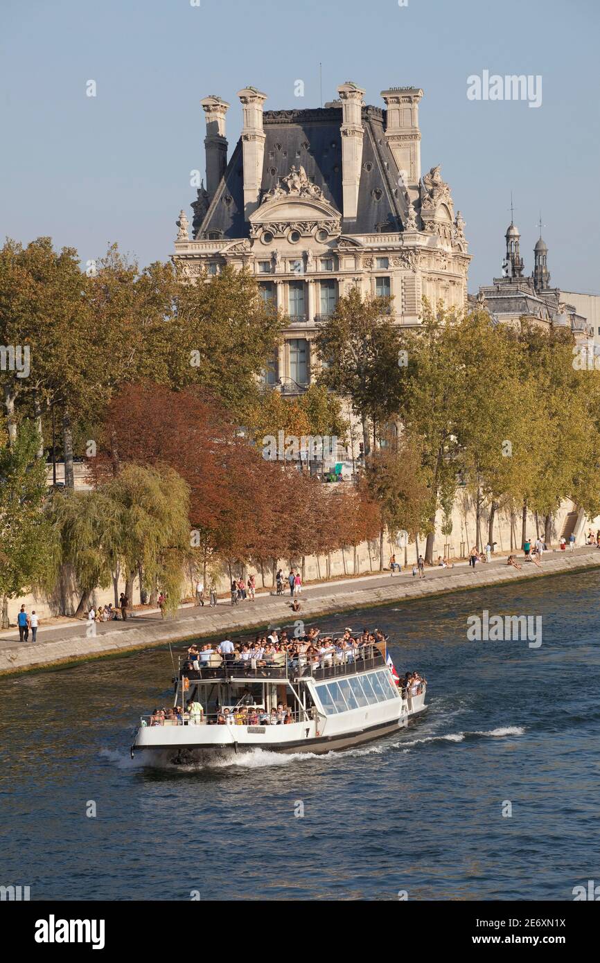 Excursión en barco por el Sena al fondo el Musee De Louvre Foto de stock