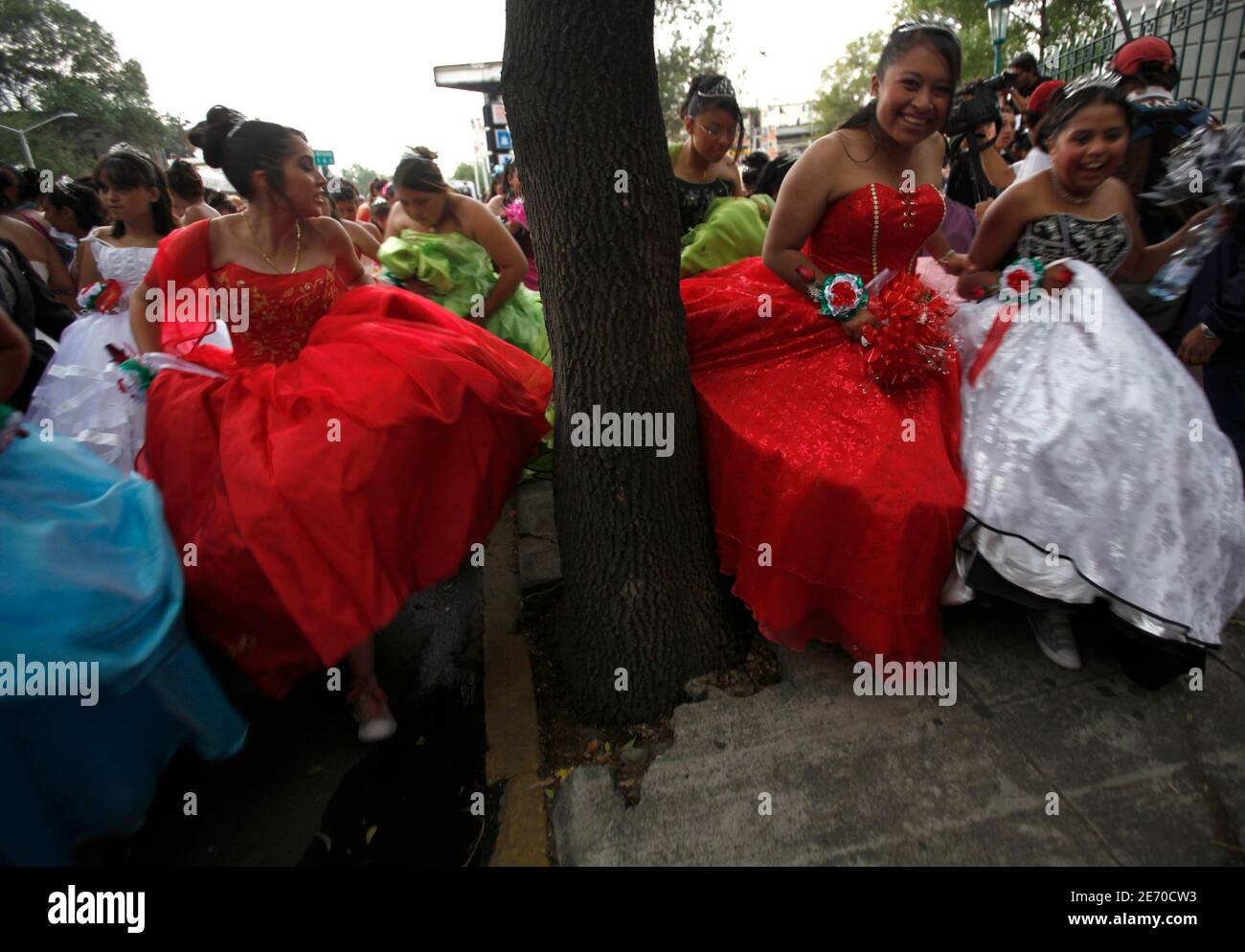 Las niñas vestidas con vestidos de noche corren en una acera en la Ciudad  de México 17 de abril de 2010. Más de 300 niñas se vestieron para su  cumpleaños número 15 (