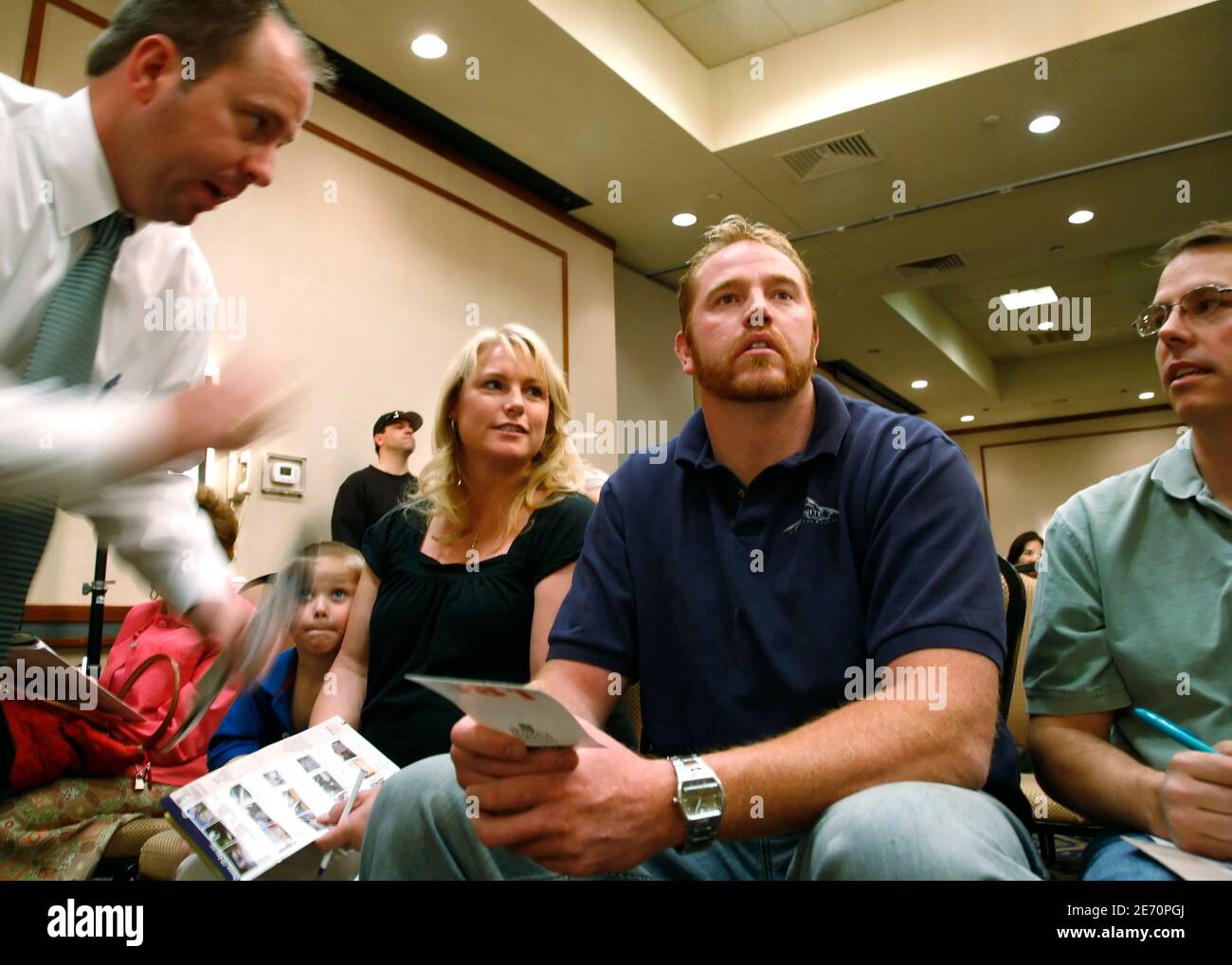 Brad Pace (L) de Hudson & Marshall Subastas anima a Ryan Davis a aumentar  su oferta en una casa durante una subasta de casas hipotecadas en Denver 19  de abril de 2008.