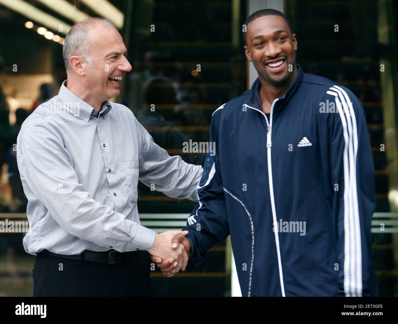 Erich Stamminger (L), President and CEO of Adidas brand, and NBA's Washington Wizards guard Gilbert Arenas shake hands during the opening ceremony of the new the largest store worldwide, Adidas
