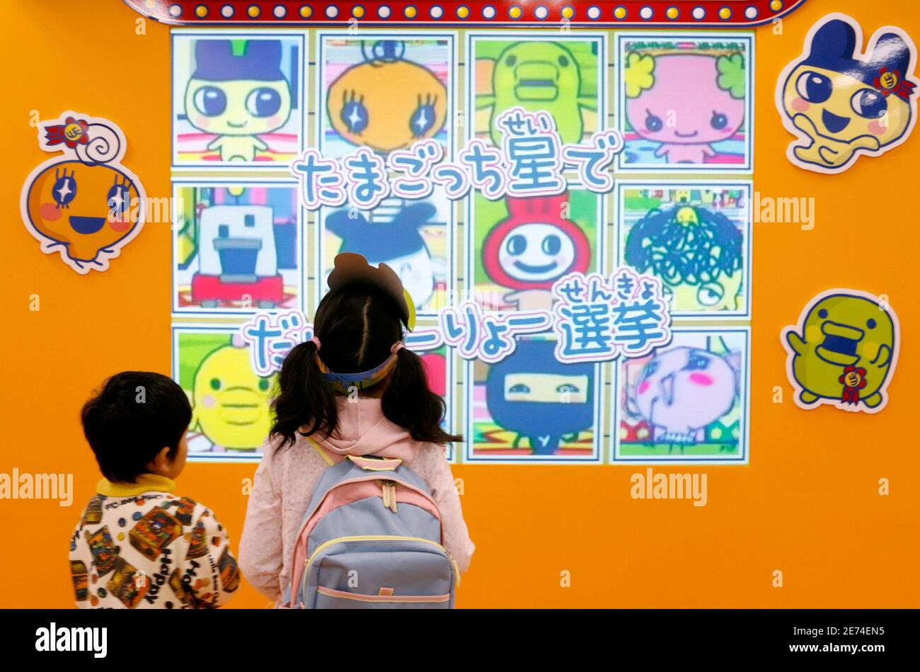 Children watch an advertisement of a Tamagotchi game software for the  Nintendo Wii at an event of Tamagotchi in Tokyo November 18, 2006.  REUTERS/Kiyoshi Ota (JAPAN Fotografía de stock - Alamy