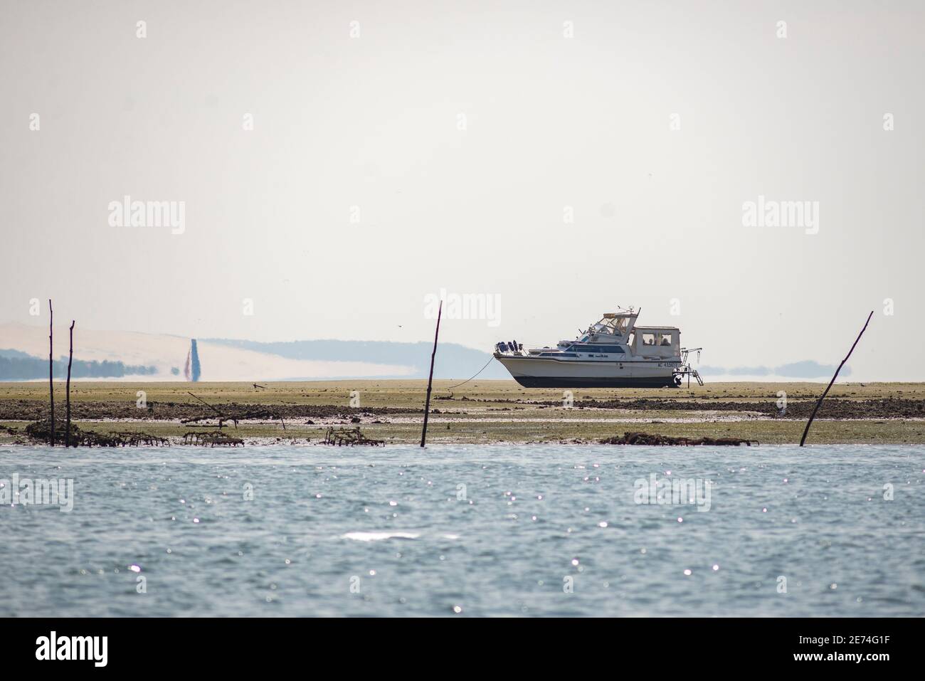 Barco a motor en la bahía de Arcachon, Gironde, Francia. Durante la marea baja amarrados barcos salen del agua Foto de stock