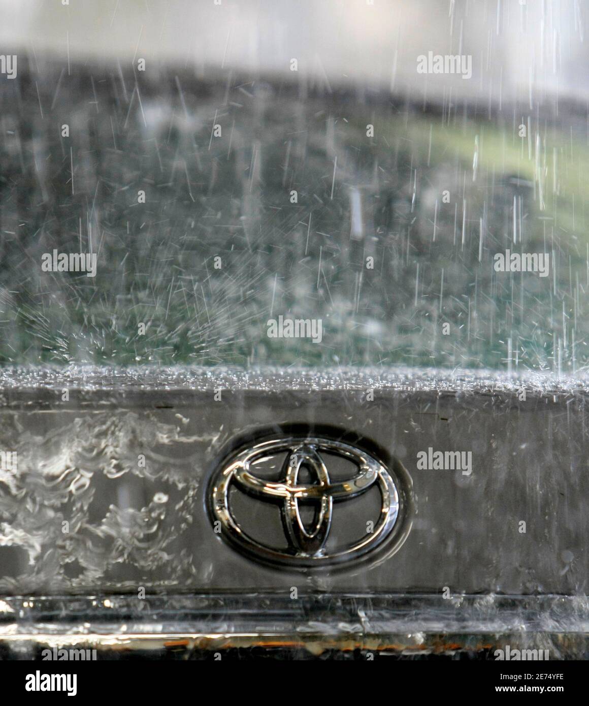 Toyota Motor Corp's logo on a car is seen during a demonstration of the hi-function shower test at its quality control facility in the headquarters in Toyota, central Japan, March 30, 2010. REUTERS/Kim Kyung-Hoon (JAPAN - Tags: TRANSPORT BUSINESS) Foto de stock
