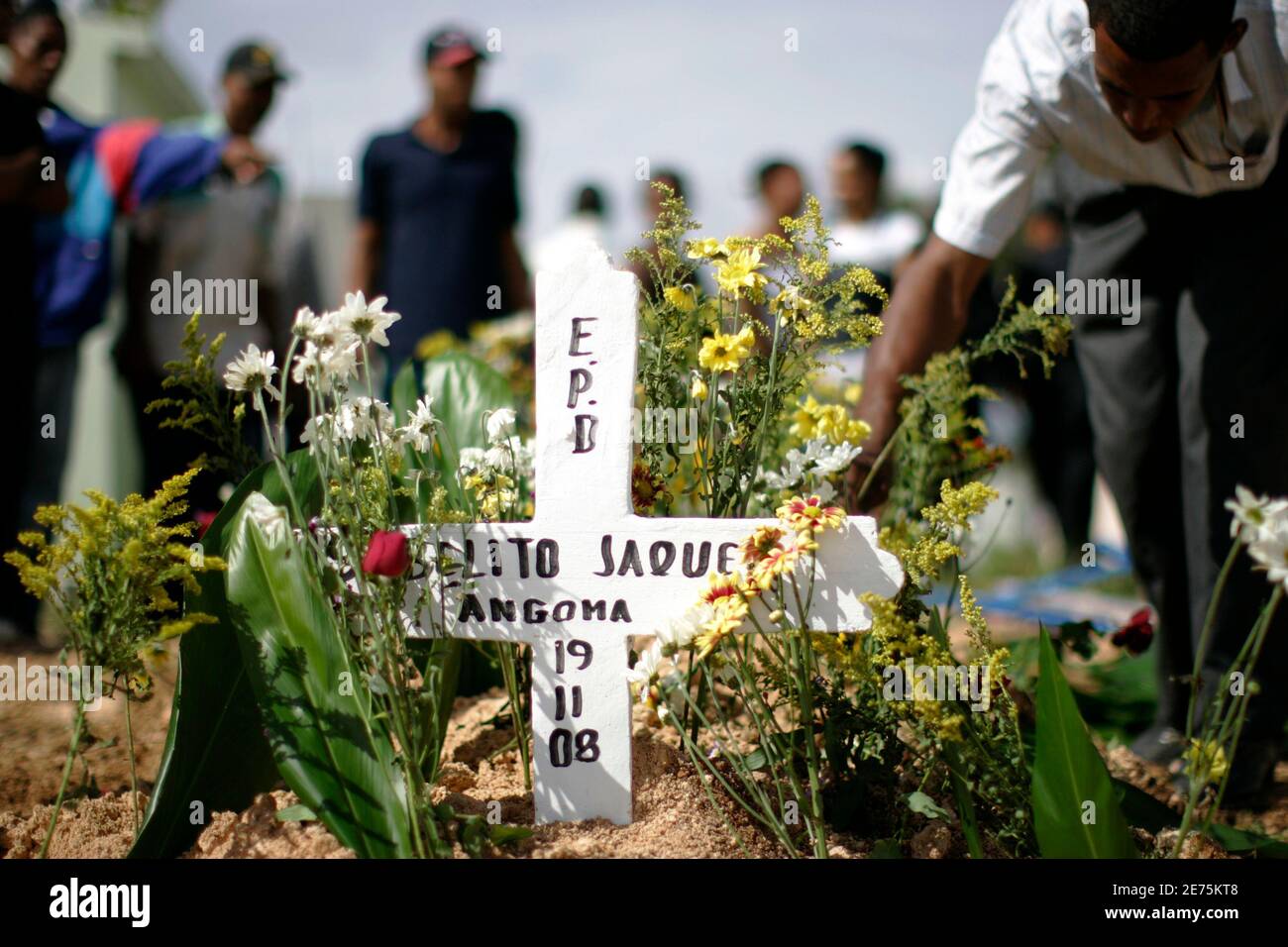 Los familiares colocan flores en la tumba del sargento Roberto Jaques,  miembro de la unidad del Departamento Nacional de Control de Drogas (DNCD),  en un cementerio de Santo Domingo 21 de noviembre