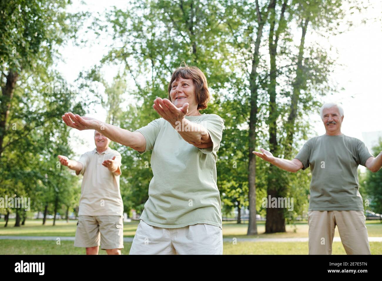 Gente mayor feliz haciendo ejercicios matutinos en el parque Foto de stock