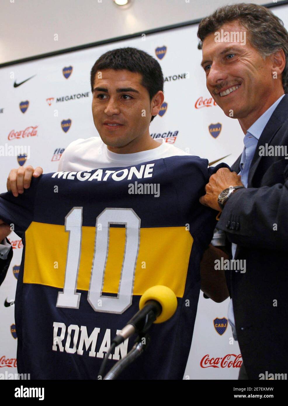 Argentine soccer striker Juan Roman Riquelme (L) and Boca Juniors'  President Mauricio Macri hold up Riquelme's new number ten jersey during  his official presentation to the media, in Buenos Aires February 12,