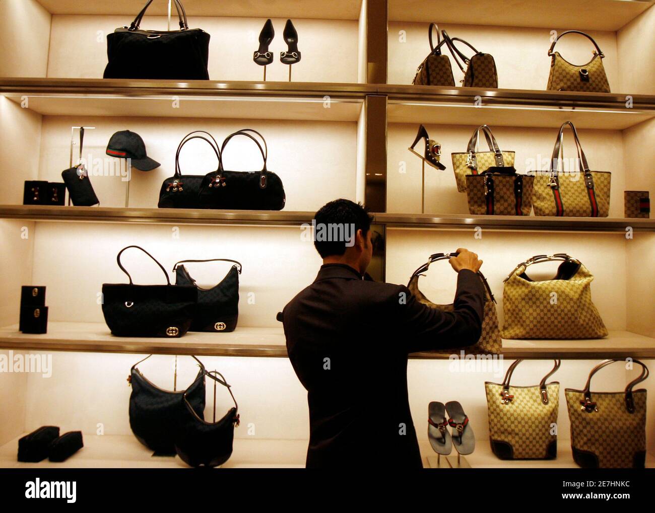 An employee arranges bags at a Gucci showroom in Mumbai November 25, 2008.  REUTERS/Arko Datta (INDIA) TO MATCH INDIA-LUXURY/SOURCE Fotografía de stock  - Alamy