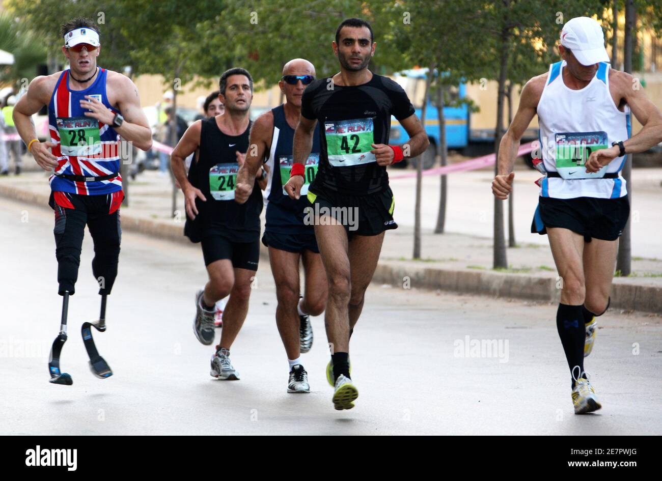 Richard Whitehead (L), un activista británico por la discapacidad que nació sin piernas, compite con otros corredores durante el Maratón anual de Beirut en Beirut, el 30 de noviembre de 2008. Miles de personas participaron en la carrera que comenzó en la capital libanesa. REUTERS/ Mohamed Azakir (LÍBANO) Foto de stock