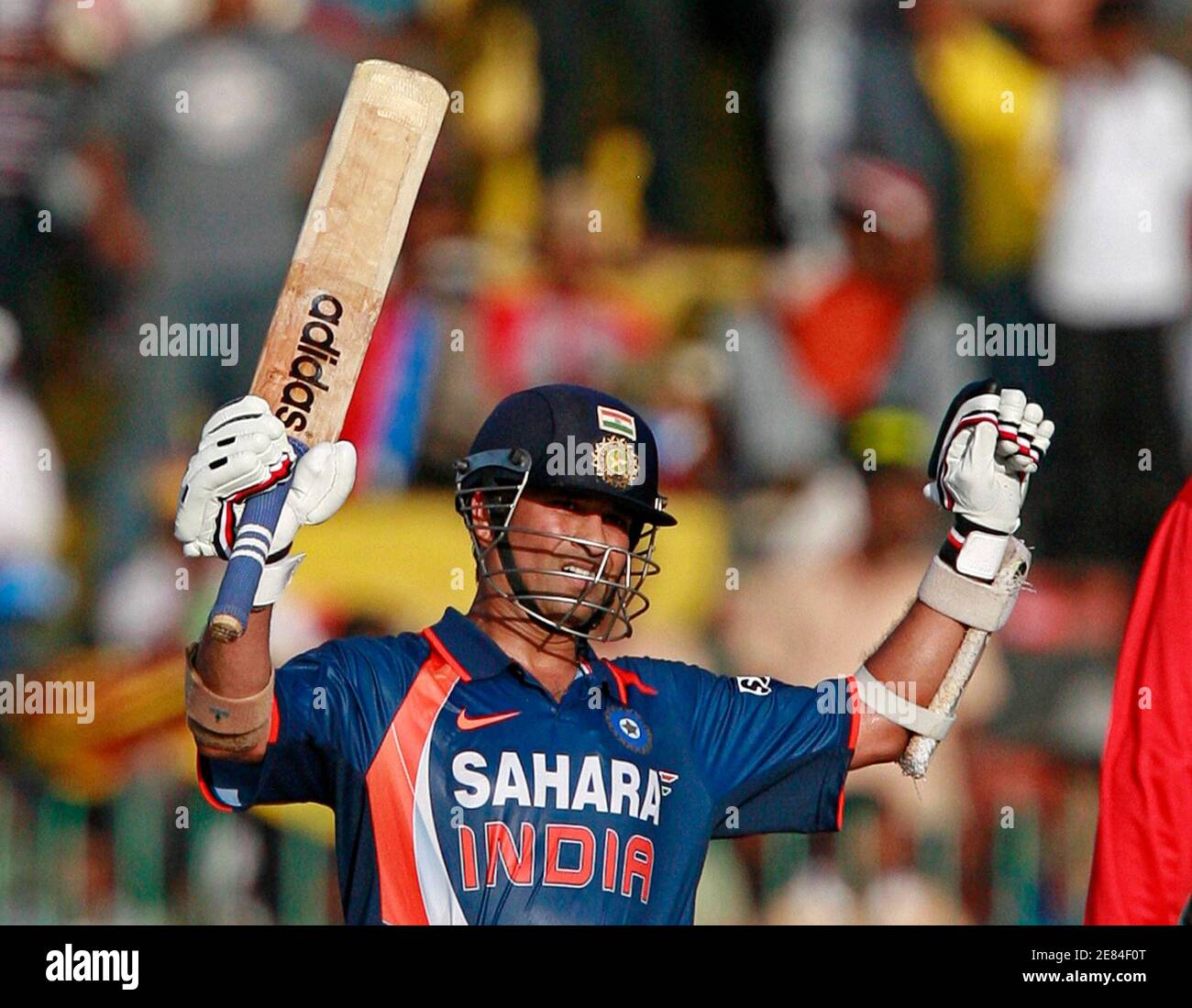 India's Sachin Tendulkar raises his bat up as he celebrates scoring a  century (100 runs) during the finals of the tri-nations one-day  international cricket series against Sri Lanka in Colombo September 14,