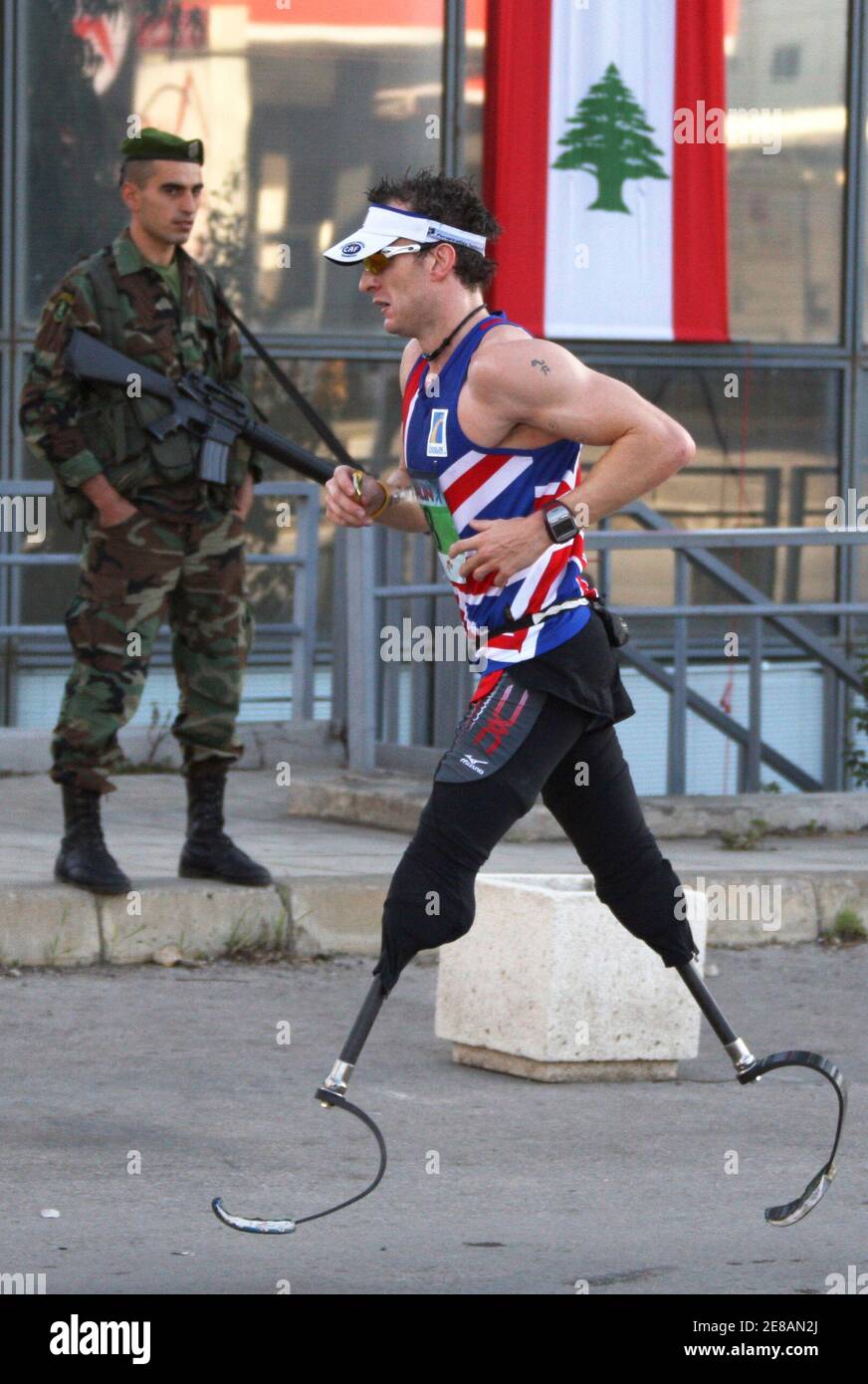 Richard Whitehead, a British disability activist who was born without legs, competes as he runs past a Lebanese soldier during the annual Beirut Marathon in Beirut, November 30, 2008. Thousands of people took part in the run which started in the Lebanese capital. REUTERS/ Mohamed Azakir (LEBANON) Foto de stock