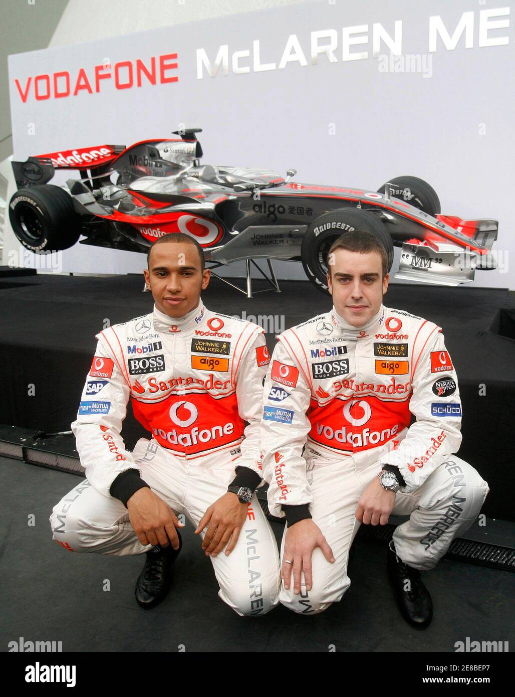 Formula One World Champion Fernando Alonso (R) and team-mate Lewis Hamilton  kneel in front of the new McLaren MP4-22 during the official presentation  of the McLaren Formula One Team in Valencia January