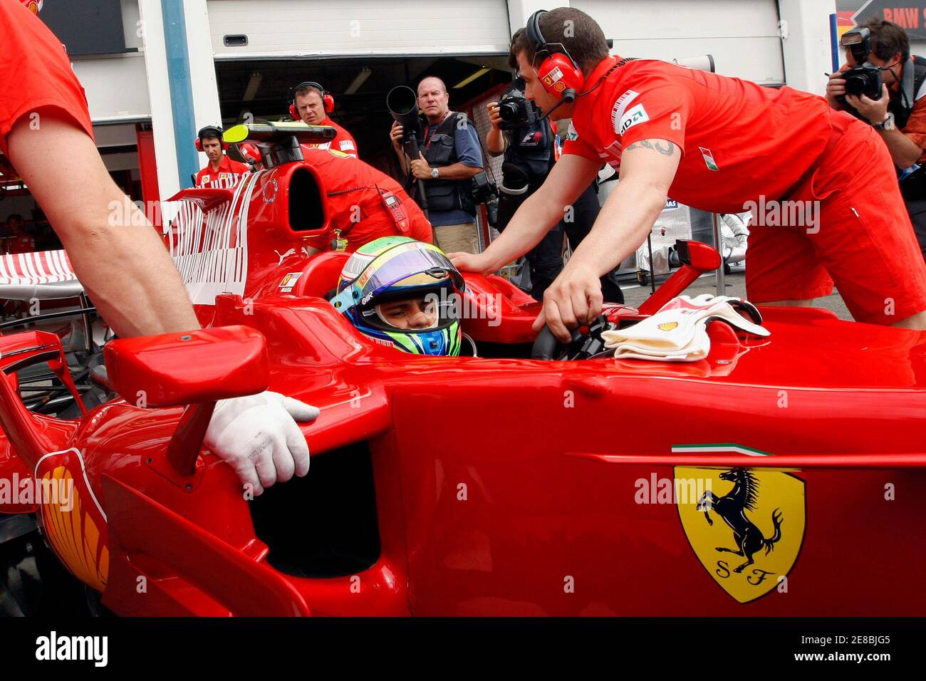 Mechanics pull the car of Ferrari Formula One driver Felipe Massa of Brazil  into the pit box during the first free practice session of the French Grand  Prix at the Magny Cours
