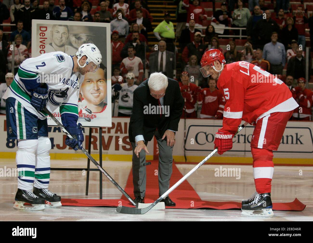 Detroit Red Wing alumnus Alex Delvecchio drops the ceremonial puck between  Vancouver Canucks Mattias Ohlund (L) and Red Wings Nicklas Lidstrom (R)  before the start of their NHL hockey game in Detroit,
