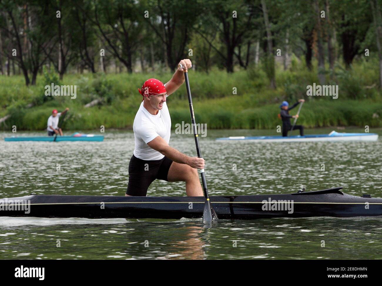 Maxim Opalev (C), de Rusia, miembro del equipo de canoa olímpica de su país, entrena cerca de Barnaul en la región de Altai el 6 de agosto de 2008. Opalev representará a Rusia en las Olimpiadas de Beijing de 2008. REUTERS/Andrei Kasprishin (RUSIA) Foto de stock