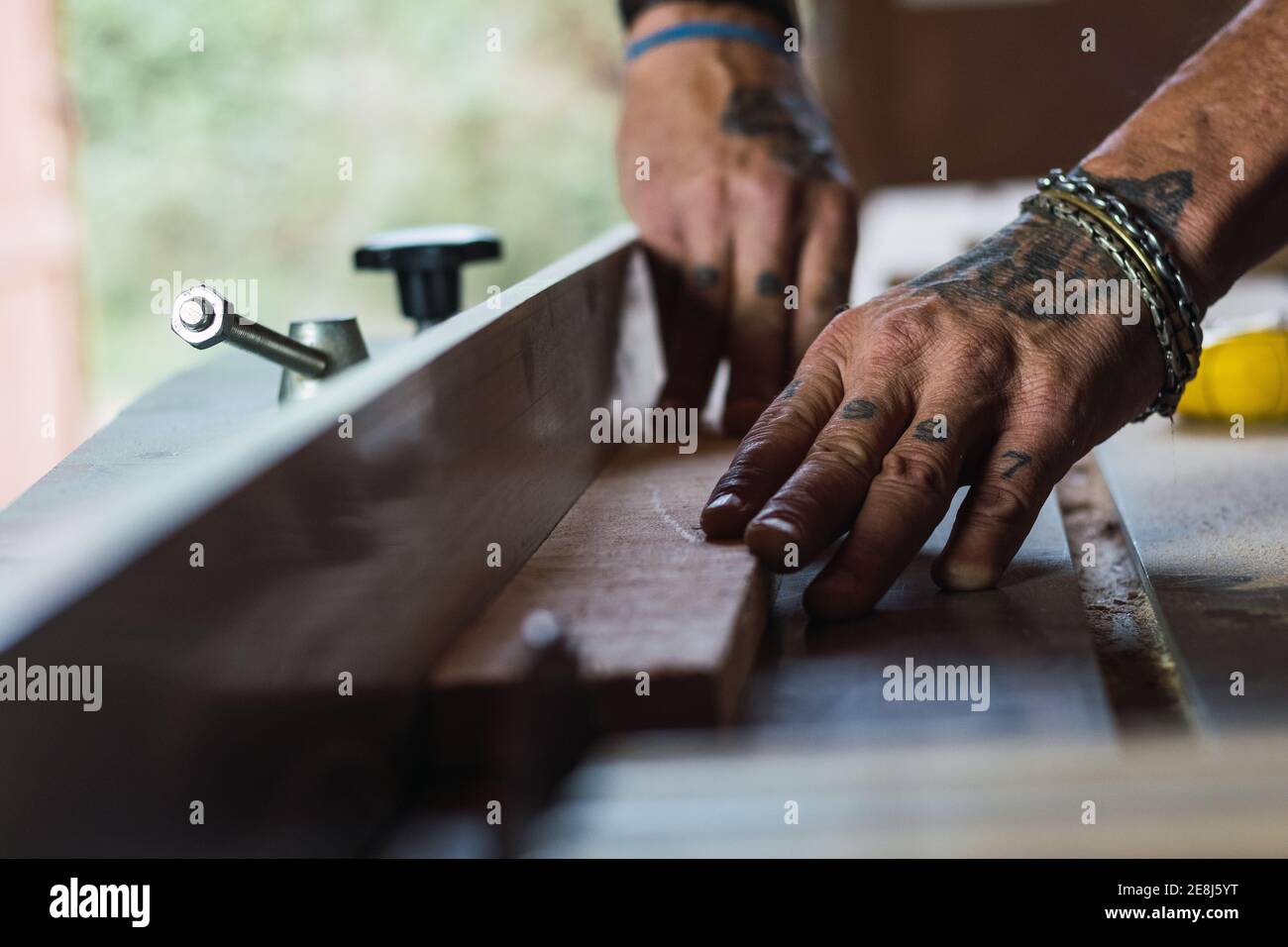 Cierre de cosecha macho irreconocible sin un corte de unión de pulgar madera con sierra circular en carpintería Foto de stock