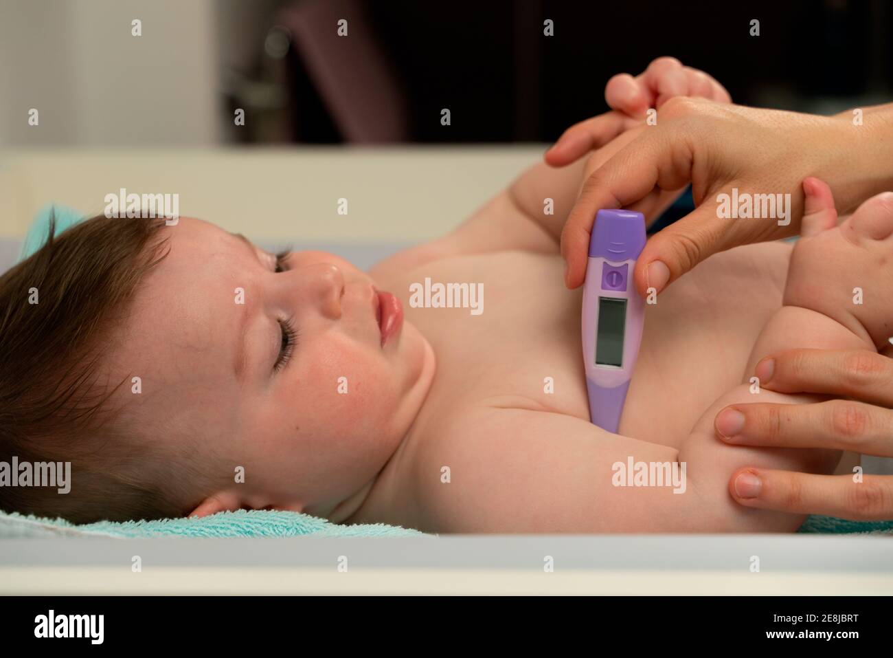 Cosecha madre amorosa medir la temperatura del bebé lindo y colocar  termómetro en la axila del bebé cuidadosamente Fotografía de stock - Alamy