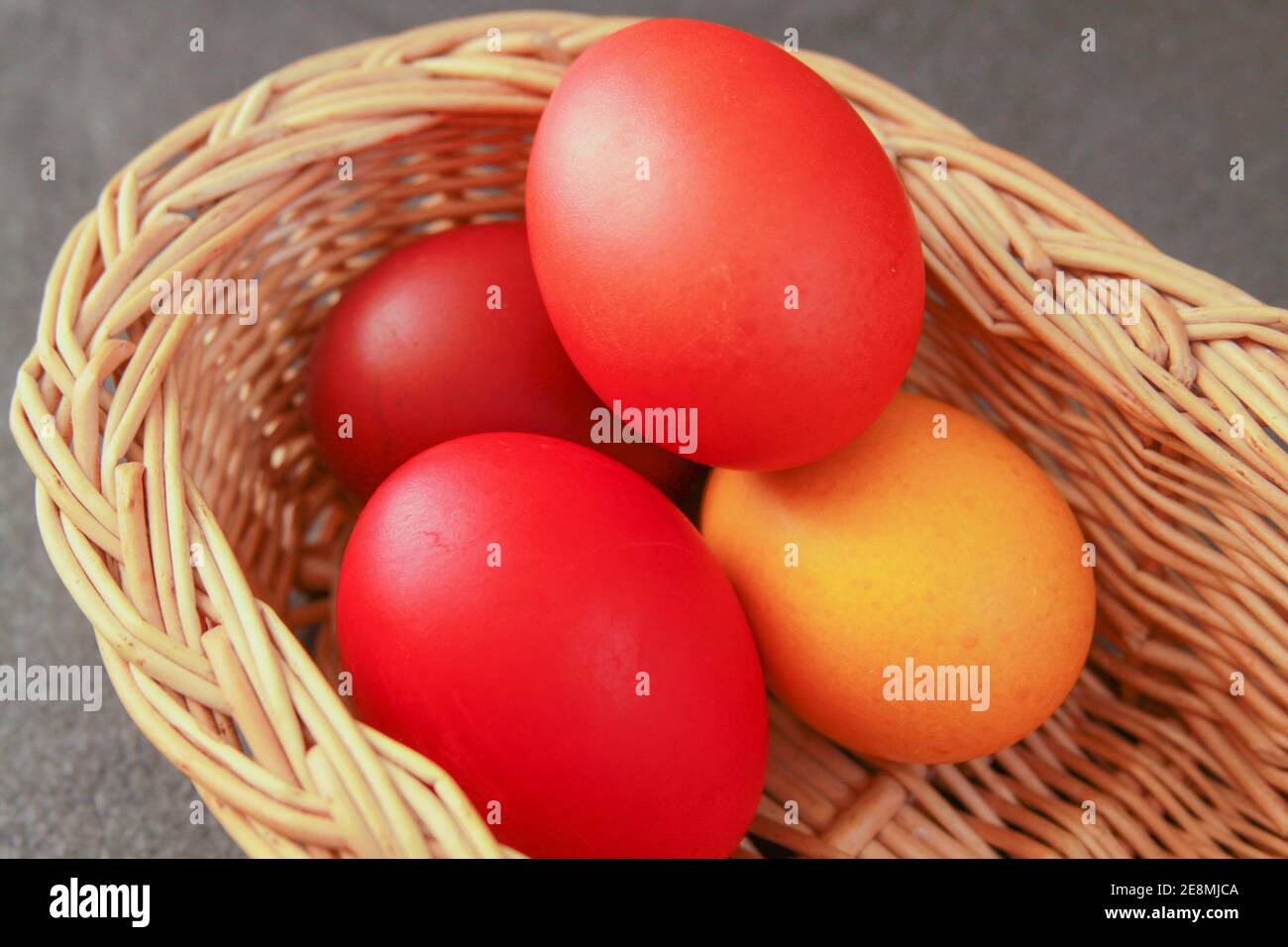 Huevos de Pascua pintados de color en la decoración de la cesta de madera en preparación para las vacaciones. Pintar huevos de pollo o pato es una tradición cristiana para celebrar Foto de stock