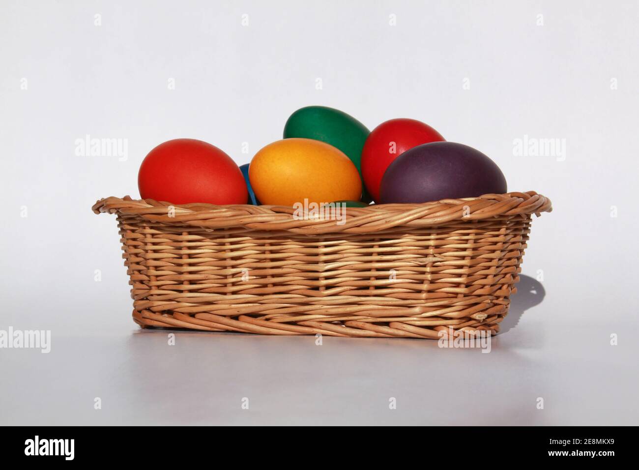 Huevos de Pascua pintados de color en la decoración de la cesta de madera en preparación para las vacaciones. Pintar huevos de pollo o pato es una tradición cristiana para celebrar Foto de stock