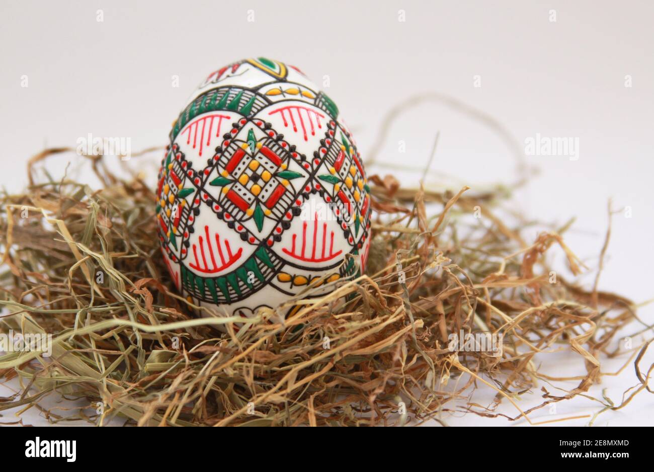 Aislado tradicional hecha a mano huevos de Pascua decoración vintage en el heno. Motivo de temporada en la mano técnica de pintura de cera de Bucovina, Rumanía utilizado para la decoración Foto de stock