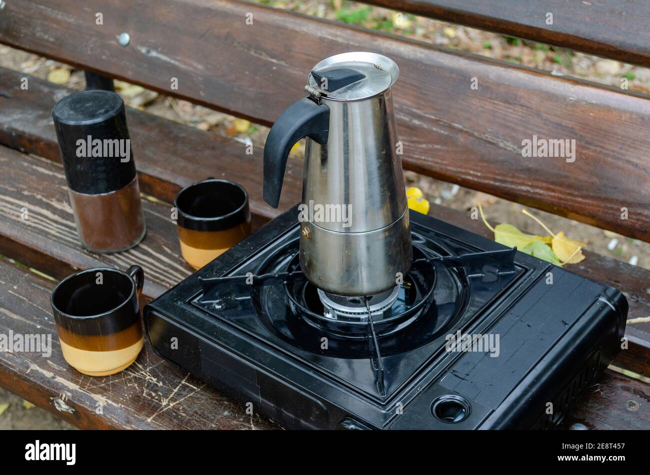 Geyser metal cafetera y estufa de gas portátil en banco del parque. Proceso  de hacer café natural durante el picnic o el viaje. Estilo de vida  Fotografía de stock - Alamy