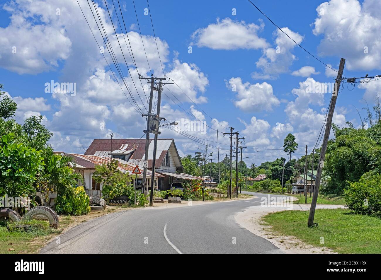 Camino rural que serpentea por el pueblo de Groningen en el distrito de Saramacca, Suriname / Surinam Foto de stock