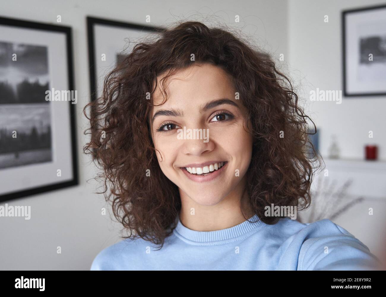 Sonriente lindo alegre joven hermosa hispana latina mirando la cámara. Foto de stock
