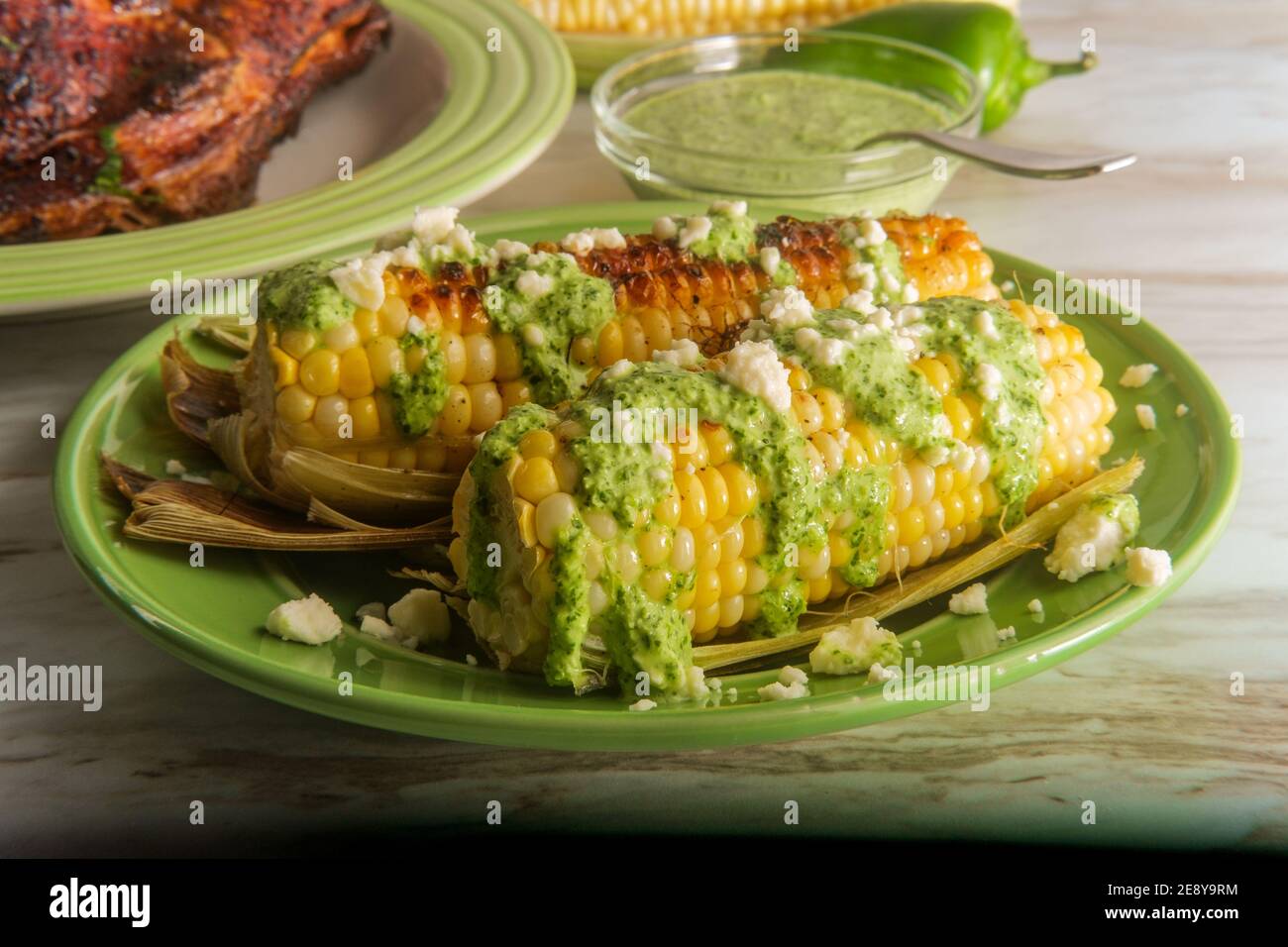 Elote peruano de maíz callejero coronado con queso fresco y aji verde  picante salsa verde Fotografía de stock - Alamy
