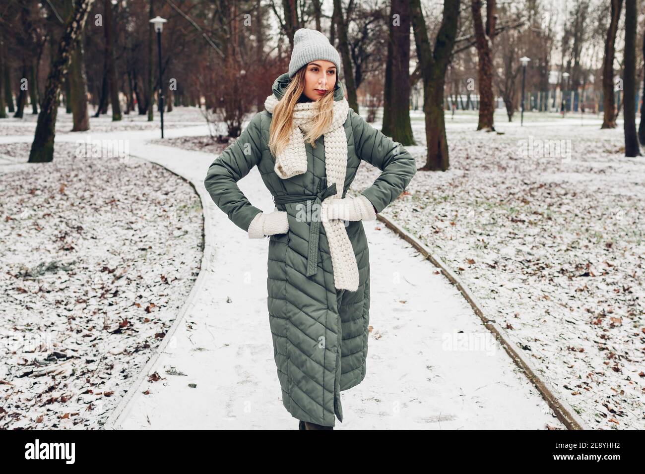 Mujer en ropa de invierno en el parque cubierto de nieve