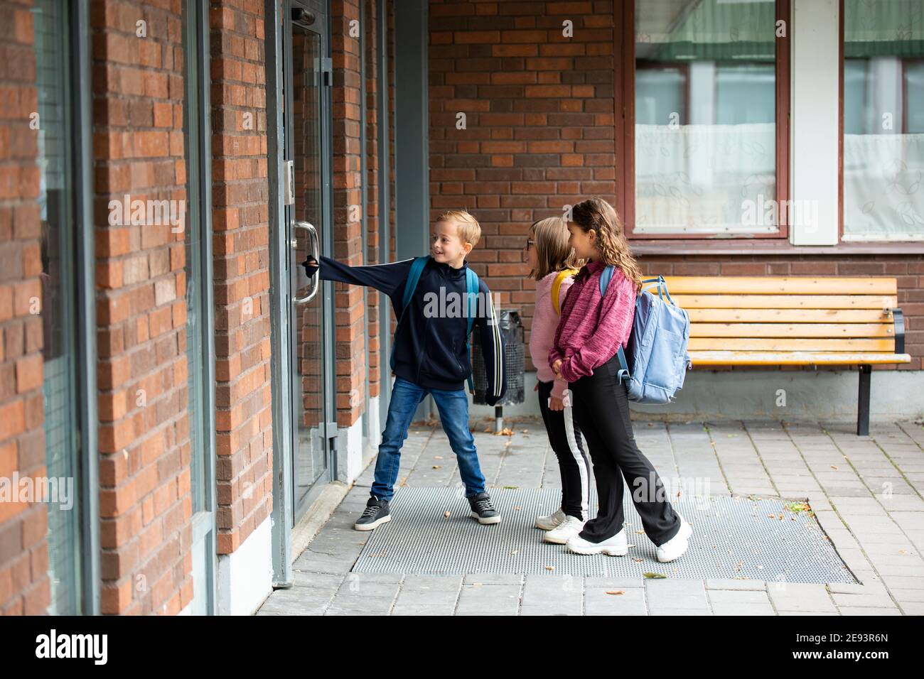 Niños abriendo la puerta de la escuela Fotografía de stock - Alamy