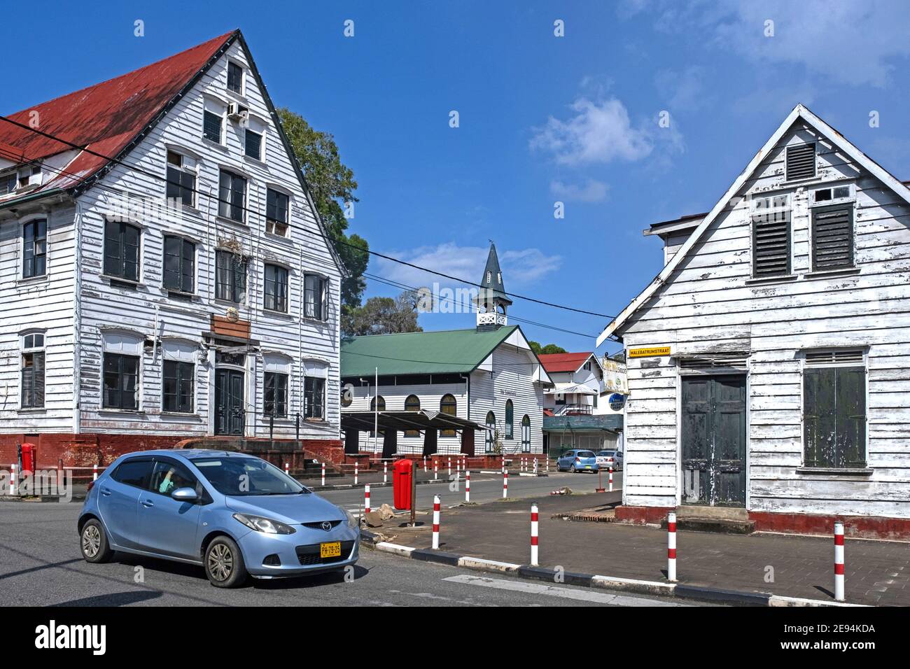 Casas blancas de madera y pequeña iglesia de estilo colonial holandés en el centro histórico de la ciudad de Paramaribo, Distrito de Paramaribo, Suriname / Surinam Foto de stock