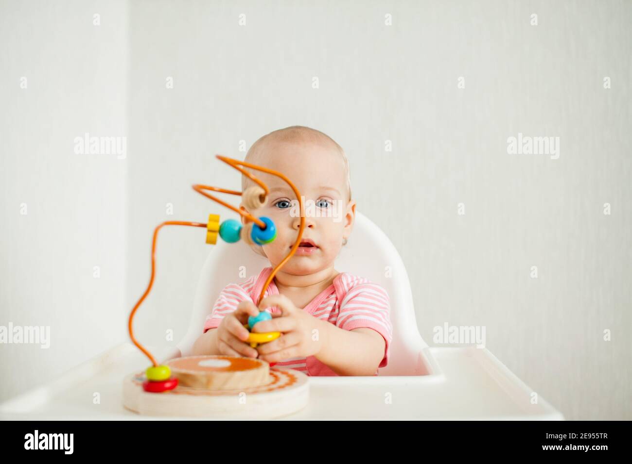 la niña juega con un juguete de laberinto educativo. Desarrollo de habilidades motoras finas y pensamiento lógico Foto de stock