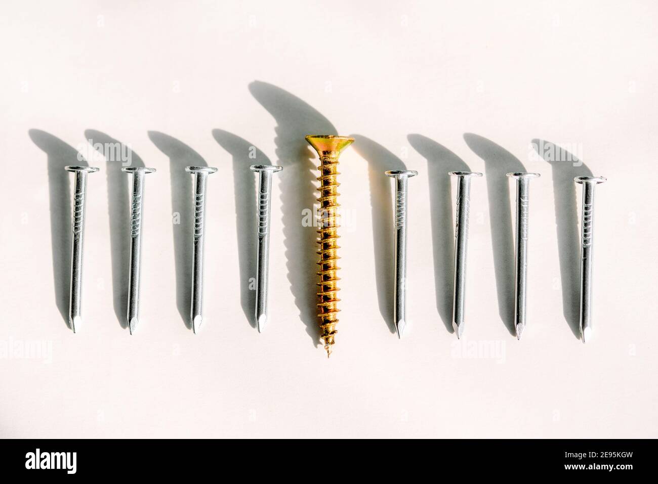 Negocio y crecimiento del negocio, individualidad e independence.One tornillo opuesto a ellos en un tablero es muchos de clavos. Un concepto sobre un tema el Foto de stock