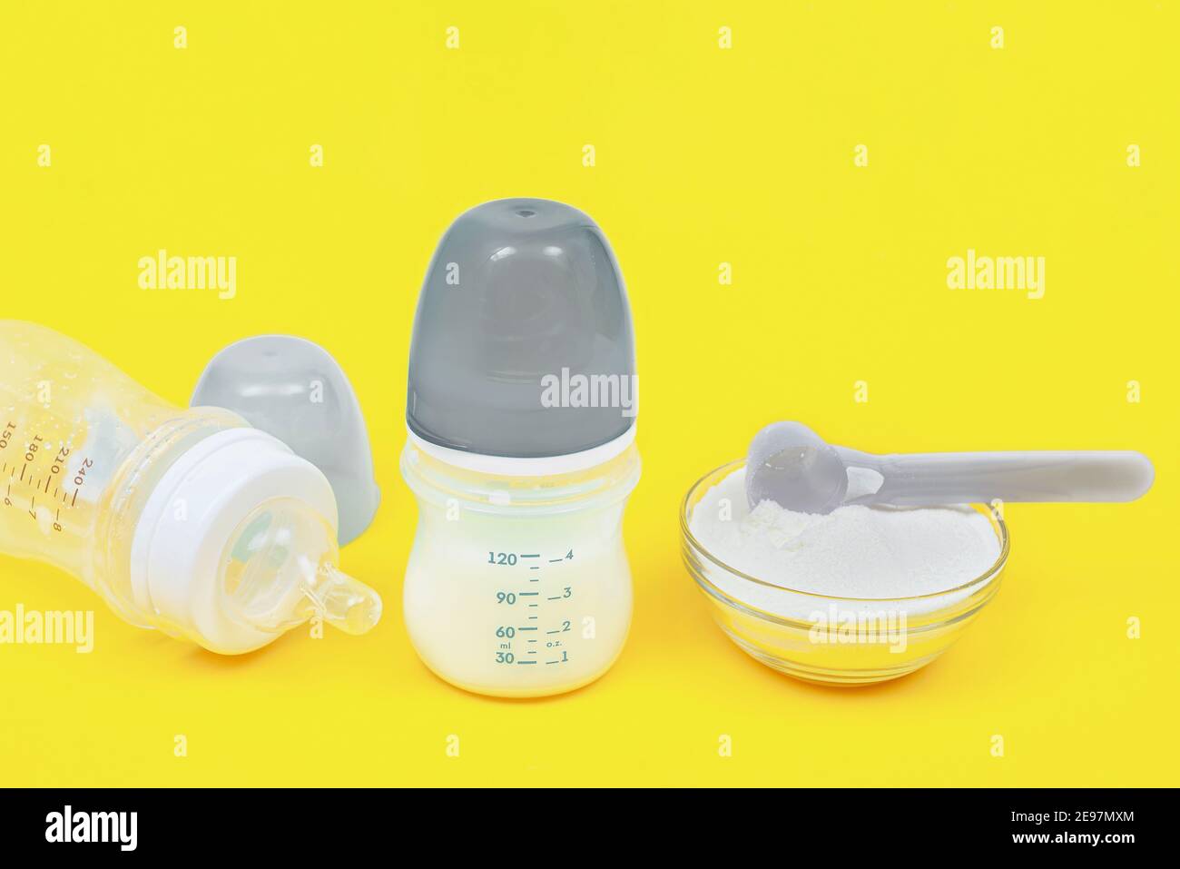 Biberones y leche para bebés. La composición está enmarcada en los colores  del año 2021. Biberones con báscula Fotografía de stock - Alamy