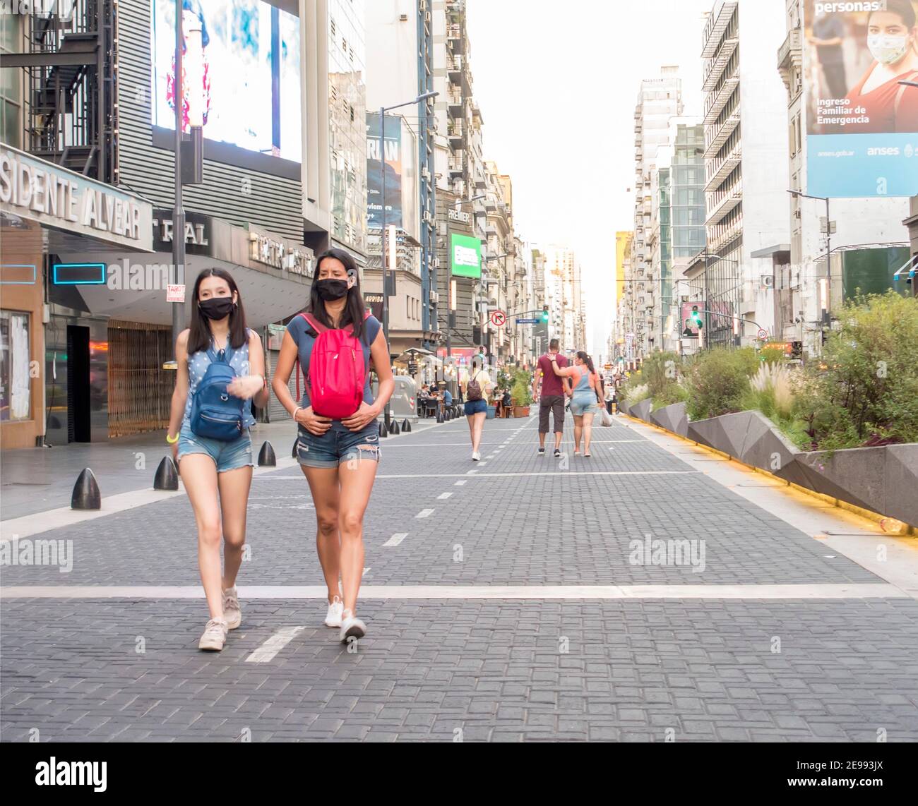 Personas que usan máscaras durante la pandemia de Covid 19 caminan por la Avenida Corrientes, Buenos Aires, Argentina Foto de stock