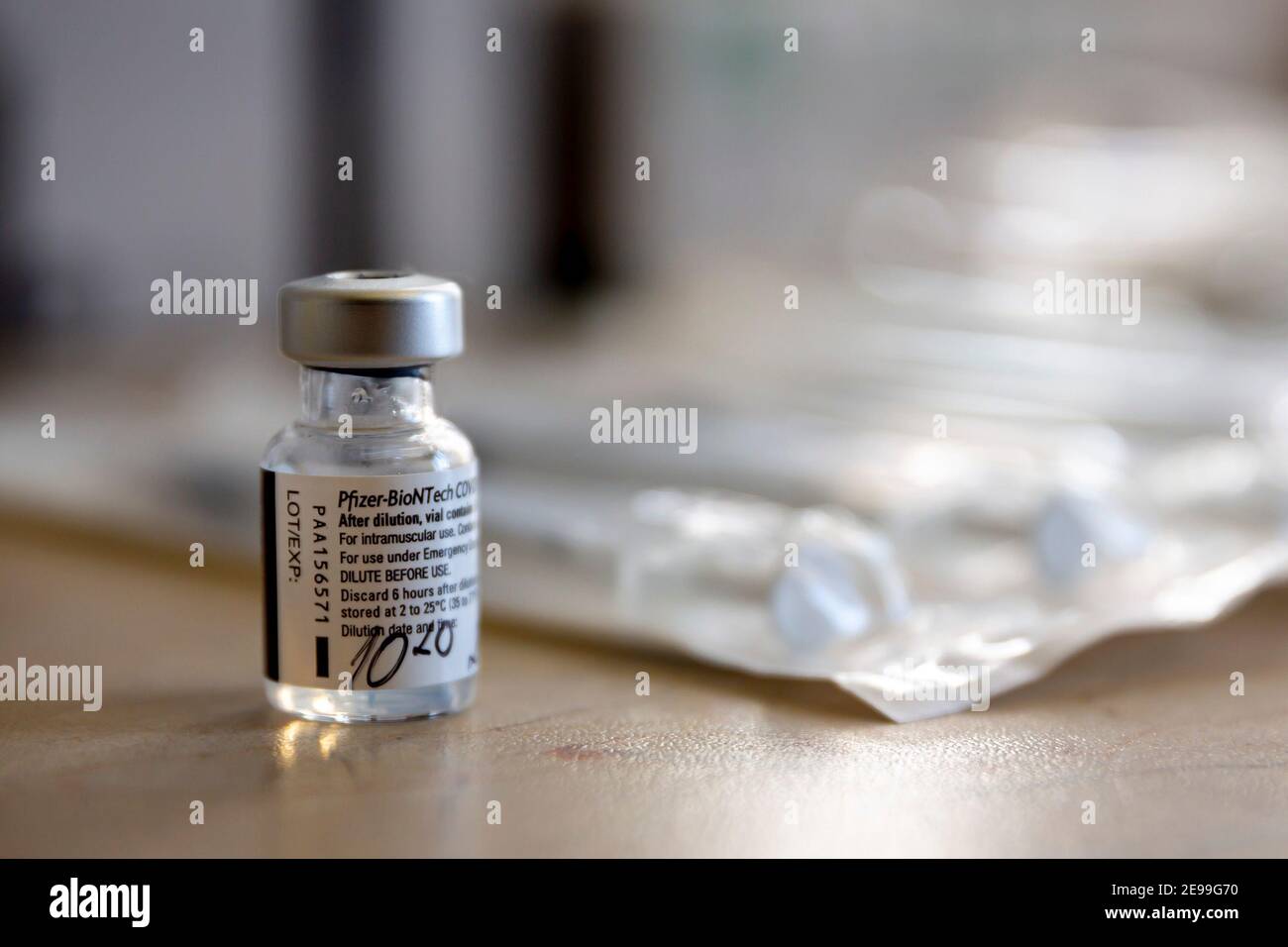 Sofía, Bulgaria - 20 de enero de 2021: Un vial de la vacuna Pfizer-BioNTech contra COVID-19 junto a las inyecciones. Foto de stock