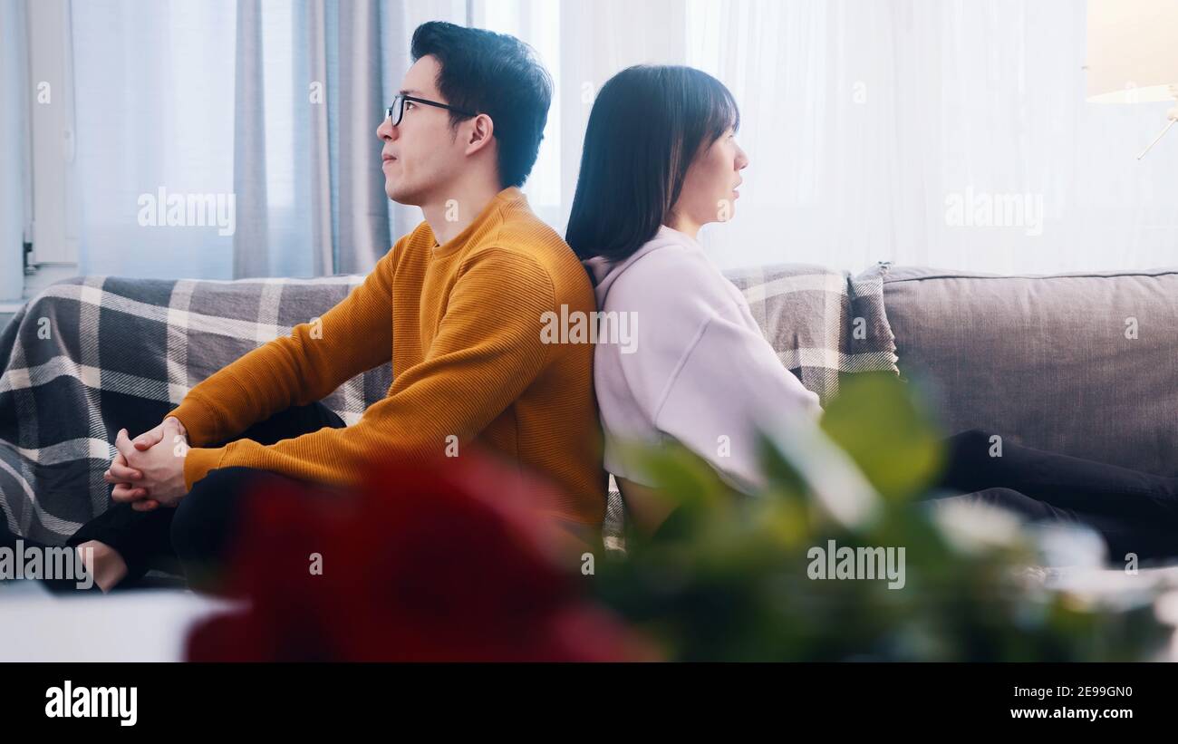 Una joven pareja asiática que tiene una discusión. Sentado de nuevo a atrás. Problemas en la relación. Foto de alta calidad Foto de stock