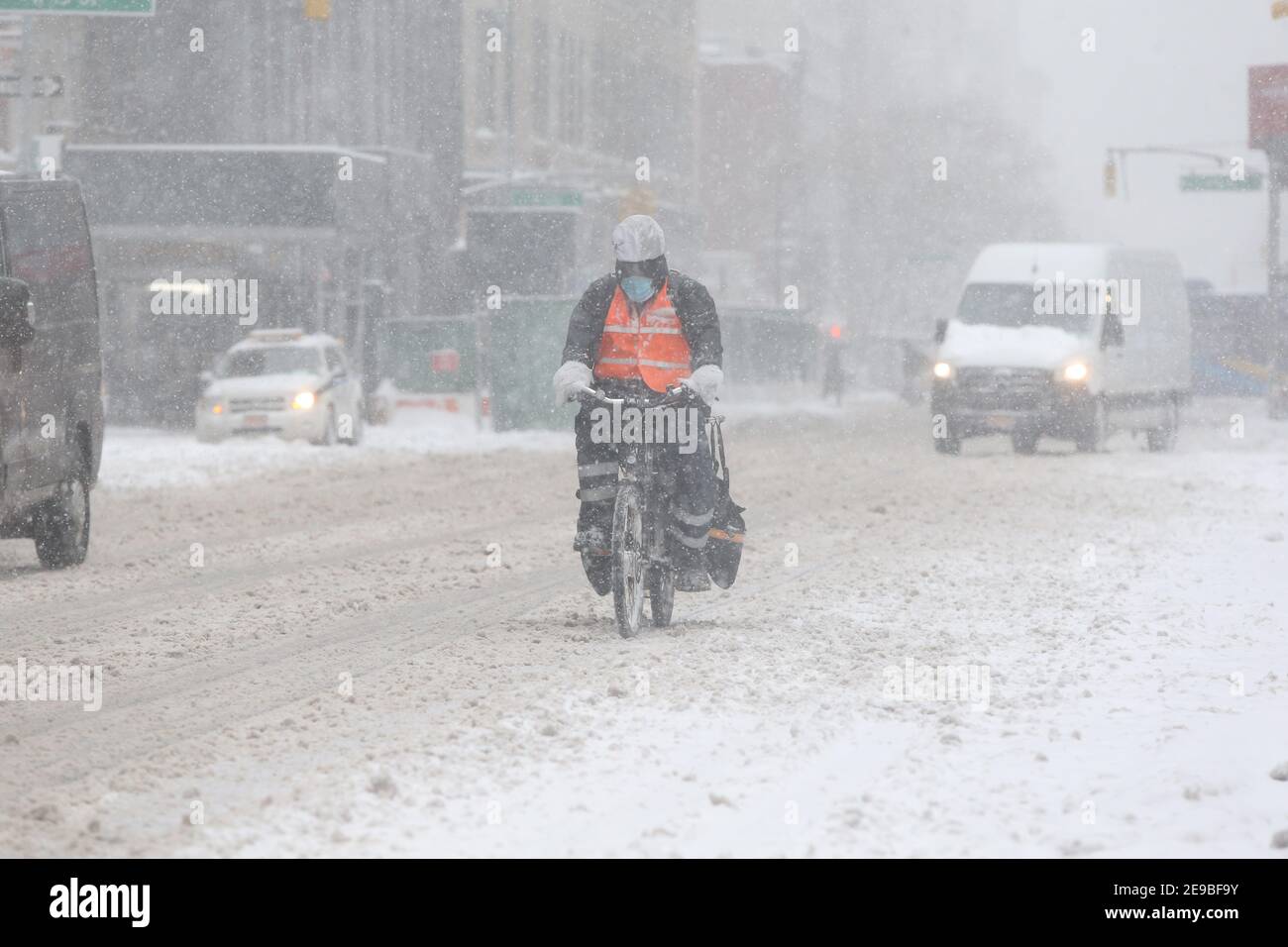 New York City , NY USA Entrega de bicicletas Persona en la nieve subiendo por Sixth Avenue Foto de stock