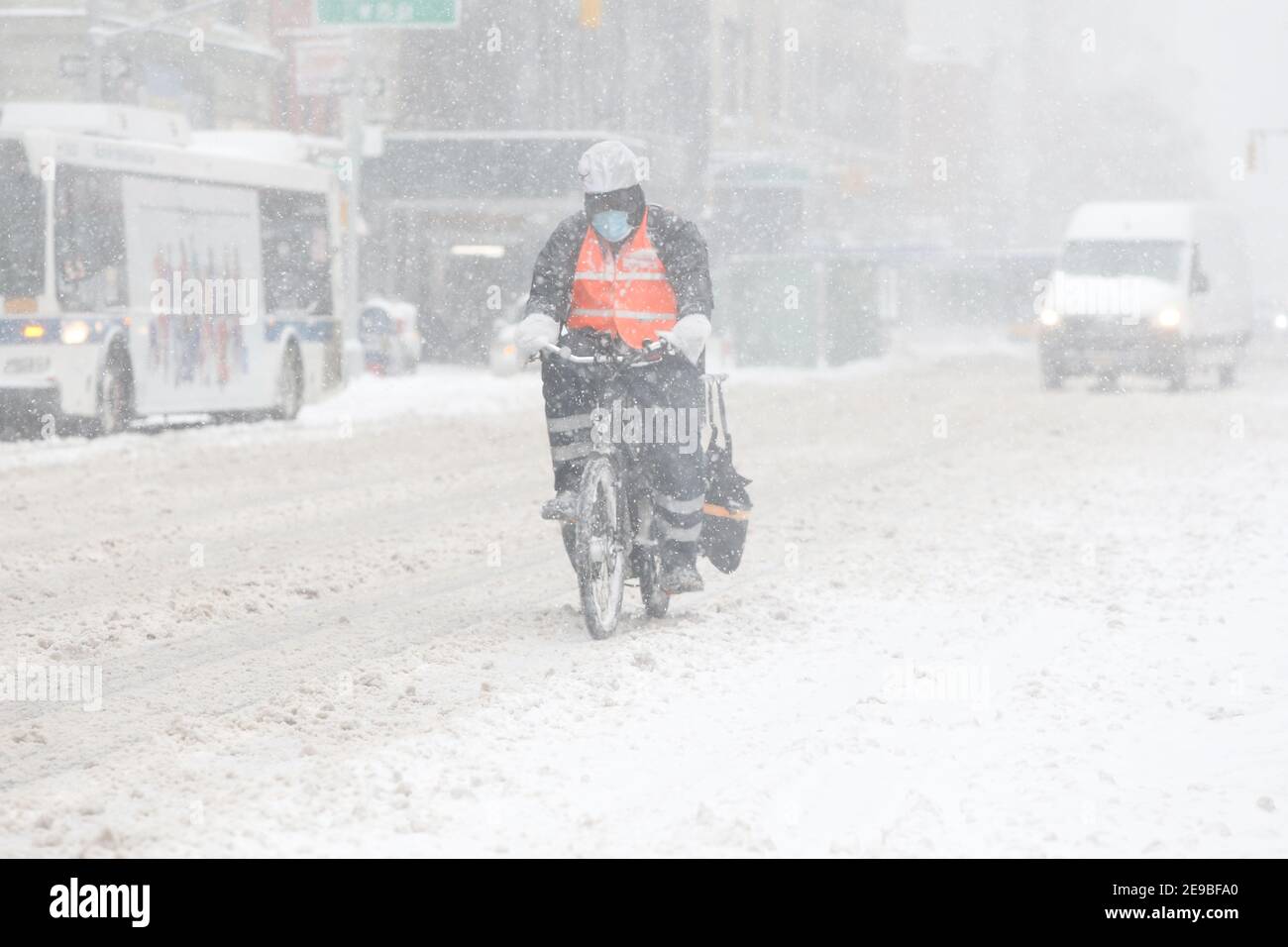 New York City , NY USA Entrega de bicicletas Persona en la nieve subiendo por Sixth Avenue Foto de stock