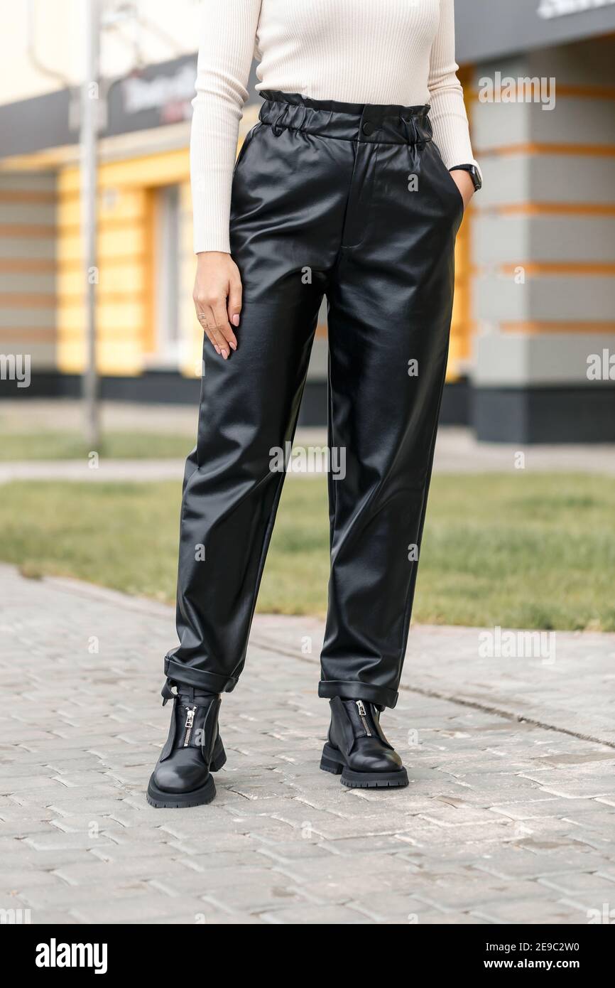 Mujer joven con pantalones de cuero negro en la calle. Moderno pantalón de  piel sintética para mujer Fotografía de stock - Alamy