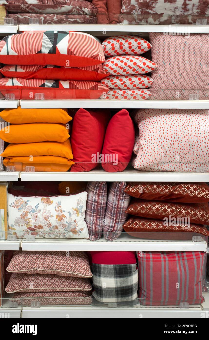 Almohadas coloridas y ropa de cama en los estantes. Enfoque selectivo. Foto de stock