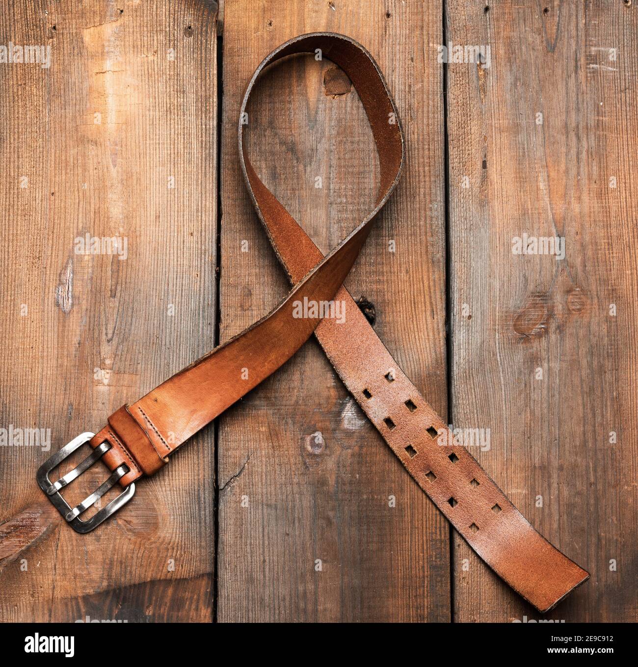 cinturón de cuero marrón para hombre con hebilla de metal sobre fondo de madera, superior Fotografía de stock - Alamy