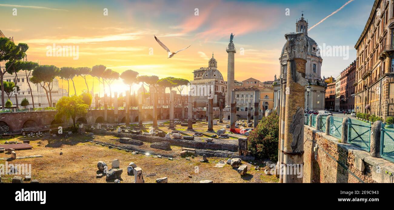 La columna de Trajano y las iglesias en Roma al atardecer. Foto de stock