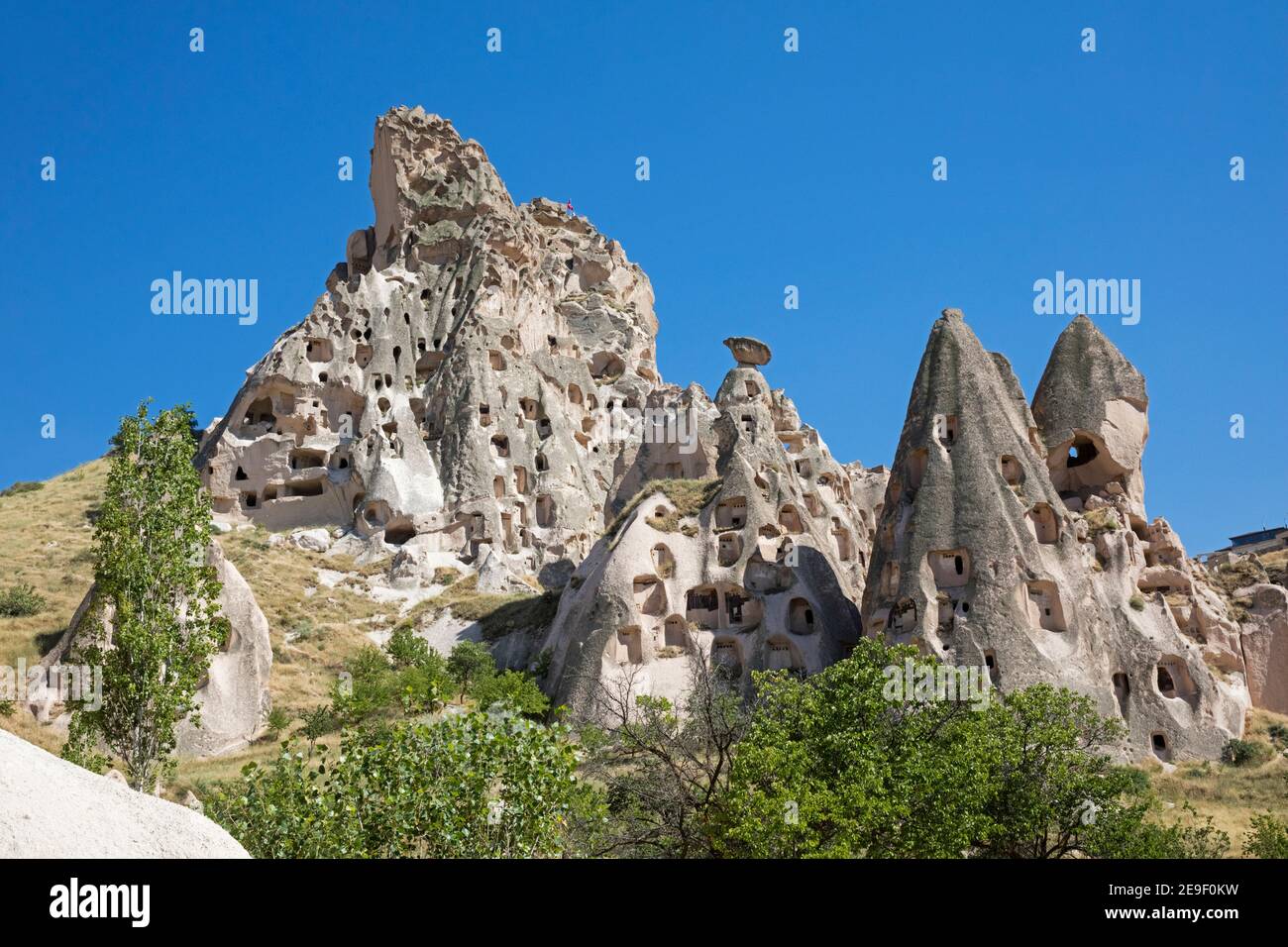 Chimeneas de hadas y casas / viviendas talladas en la roca suave en Uçhisar, Cappadocia, provincia de Nevşehir en Anatolia central, Turquía Foto de stock