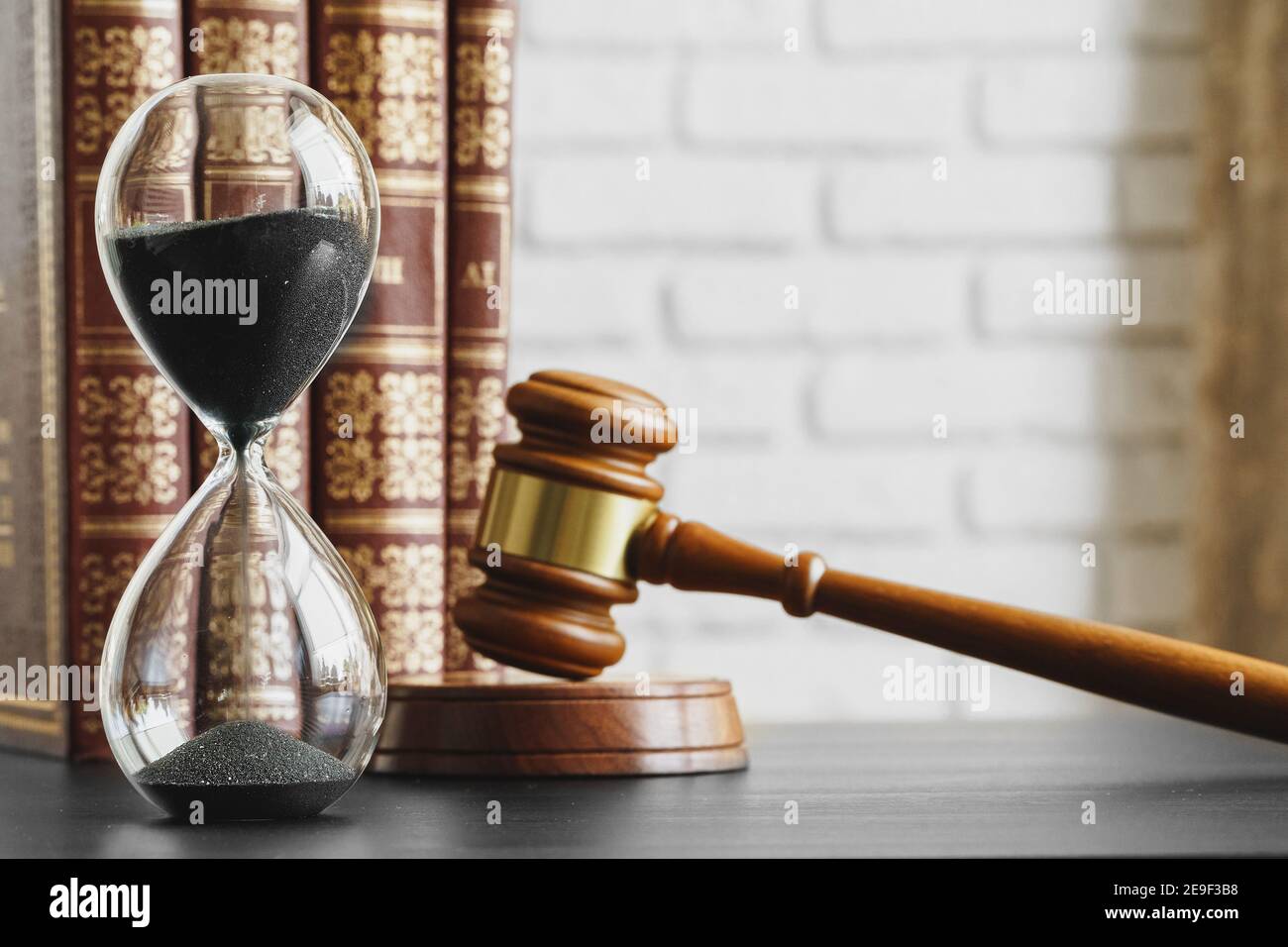 Concepto de tribunal. Reloj de arena y juez gavel en la mesa Foto de stock