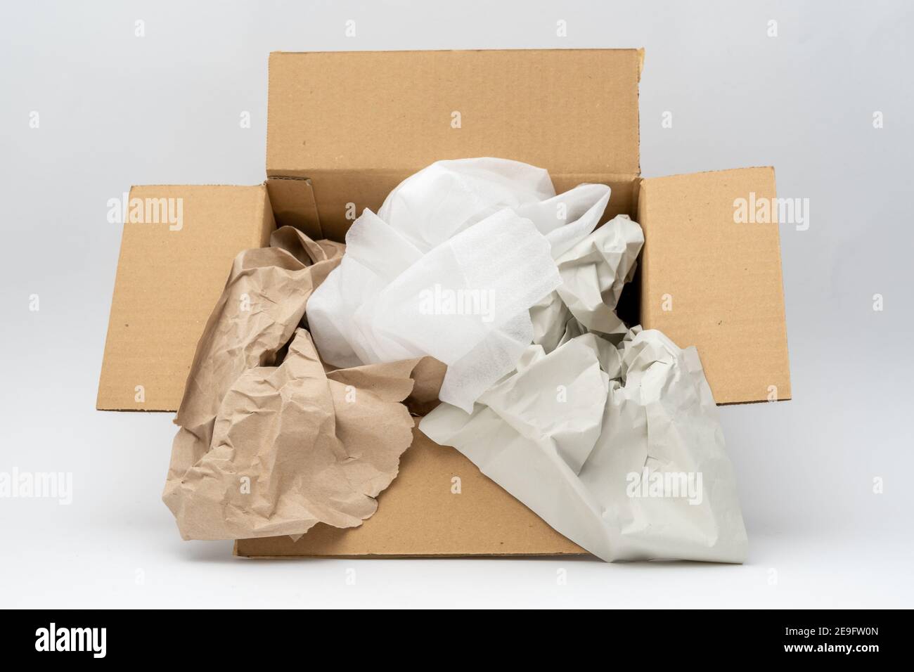 Material de embalaje dentro de una caja para el envío. Diferentes envolturas como papel reciclado y hojas de espuma de plástico para envolver algo. Foto de stock