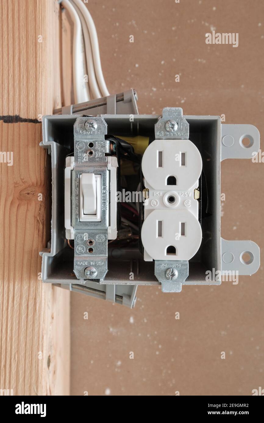 Nueva construcción, caja eléctrica de 2 módulos con interruptor DE 15 AMPERIOS y toma de corriente montada en un espárrago 2x4 Fotografía de - Alamy