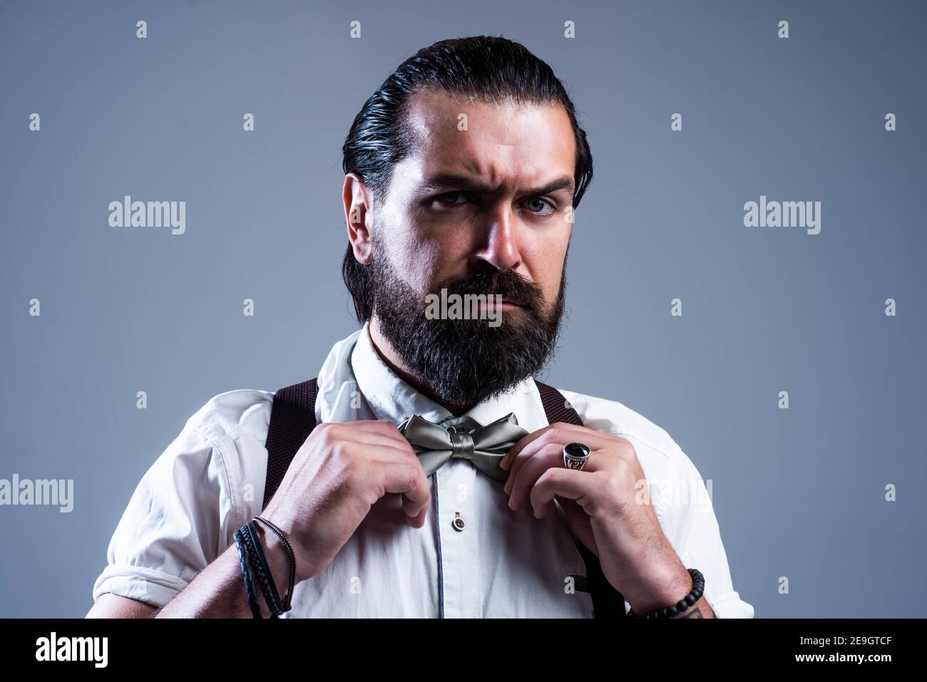 brutal hombre barbudo con bigote llevar tirantes y pajarita, look retro de  moda Fotografía de stock - Alamy